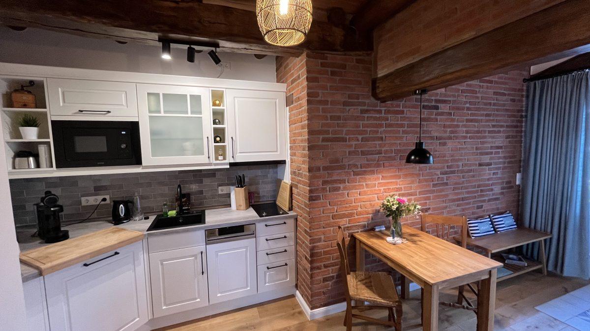 Helle Küche mit Essbereich und Backsteinwand