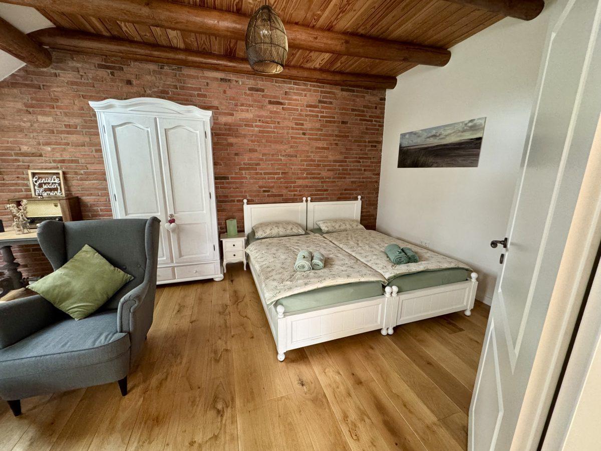 Doppelbett mit Kleiderschrank und Ohrensessel