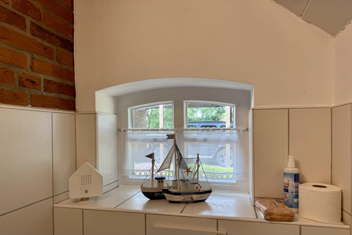 Maritime Deko mit Segelschiff am Fenster